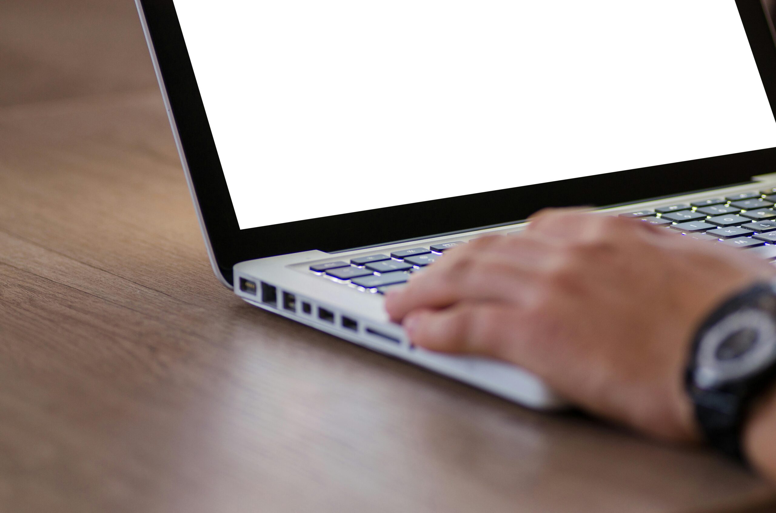 Close-up of a hand using a laptop with a blank screen, ideal for adding custom content.